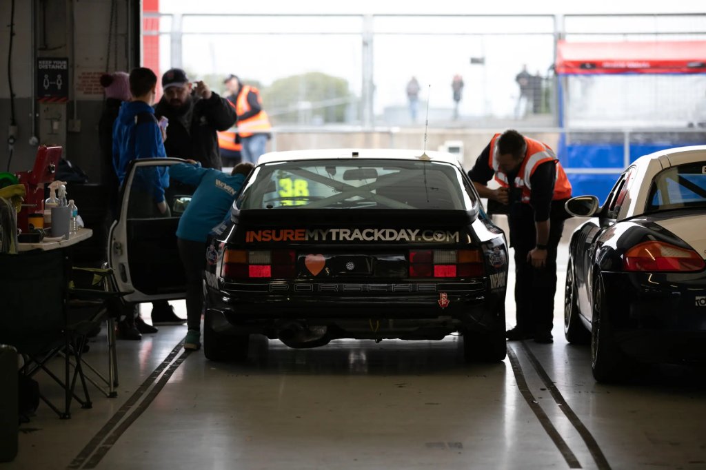 Insure My Track Day branded car in the pit garage with its crew